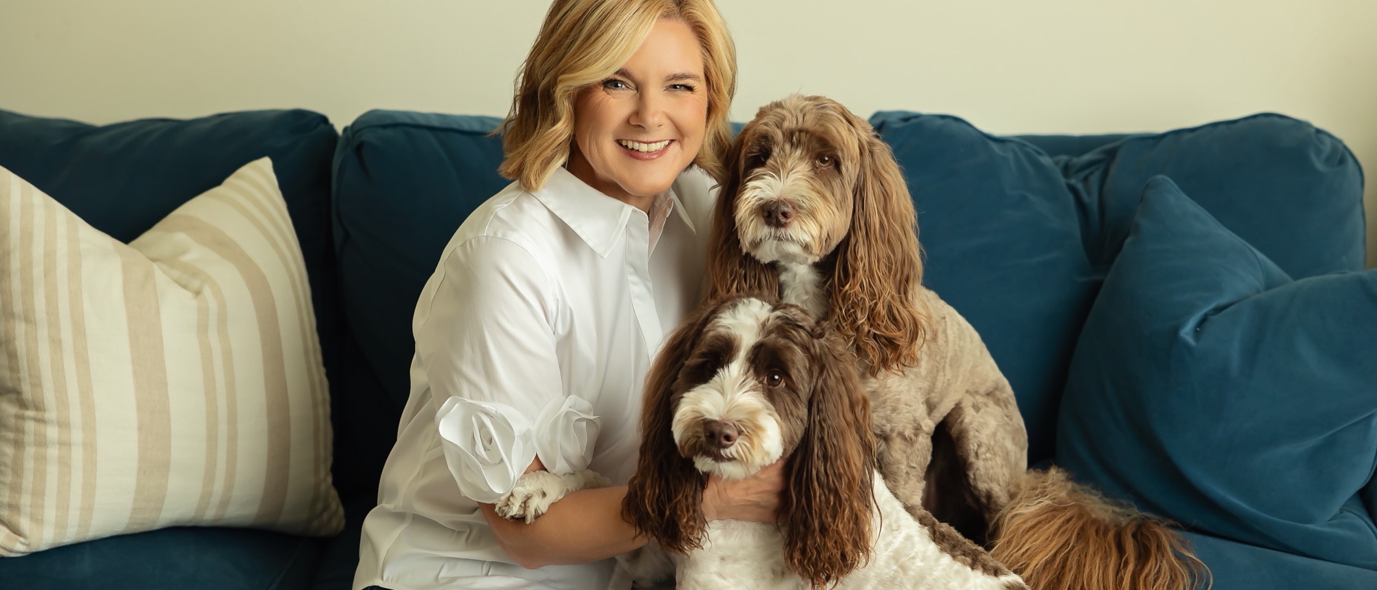 Lisa on a navy sofa with her two dogs